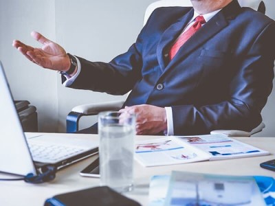 man behind a desk speaking