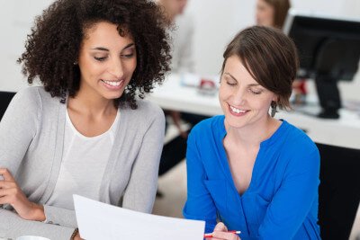 two women using a laptop