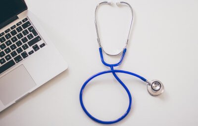 stethoscope and laptop on desk