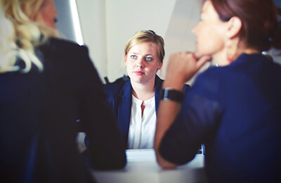 Three women sitting at table having a conversation