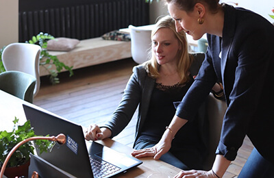 Two women working at a laptop