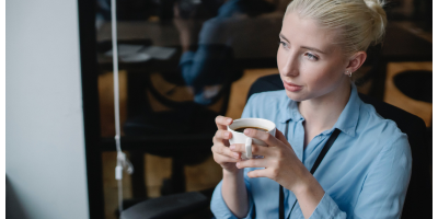 woman sitting in a cafe holding a mug of coffee