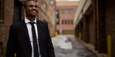 smiling businessman standing in an alley