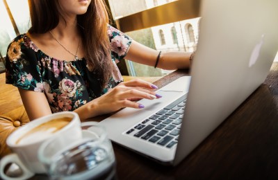 woman working on laptop with coffee nearby